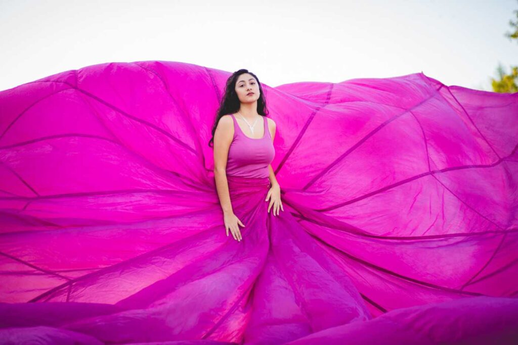 teen poses in a pink parachute dress