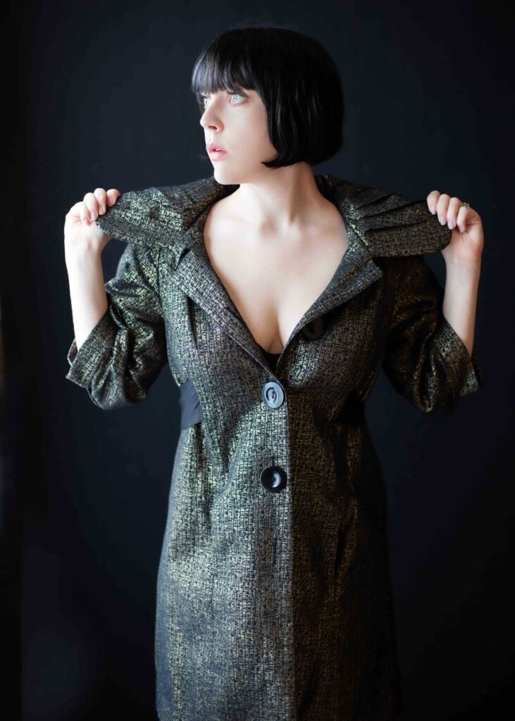 woman poses with a structured coat